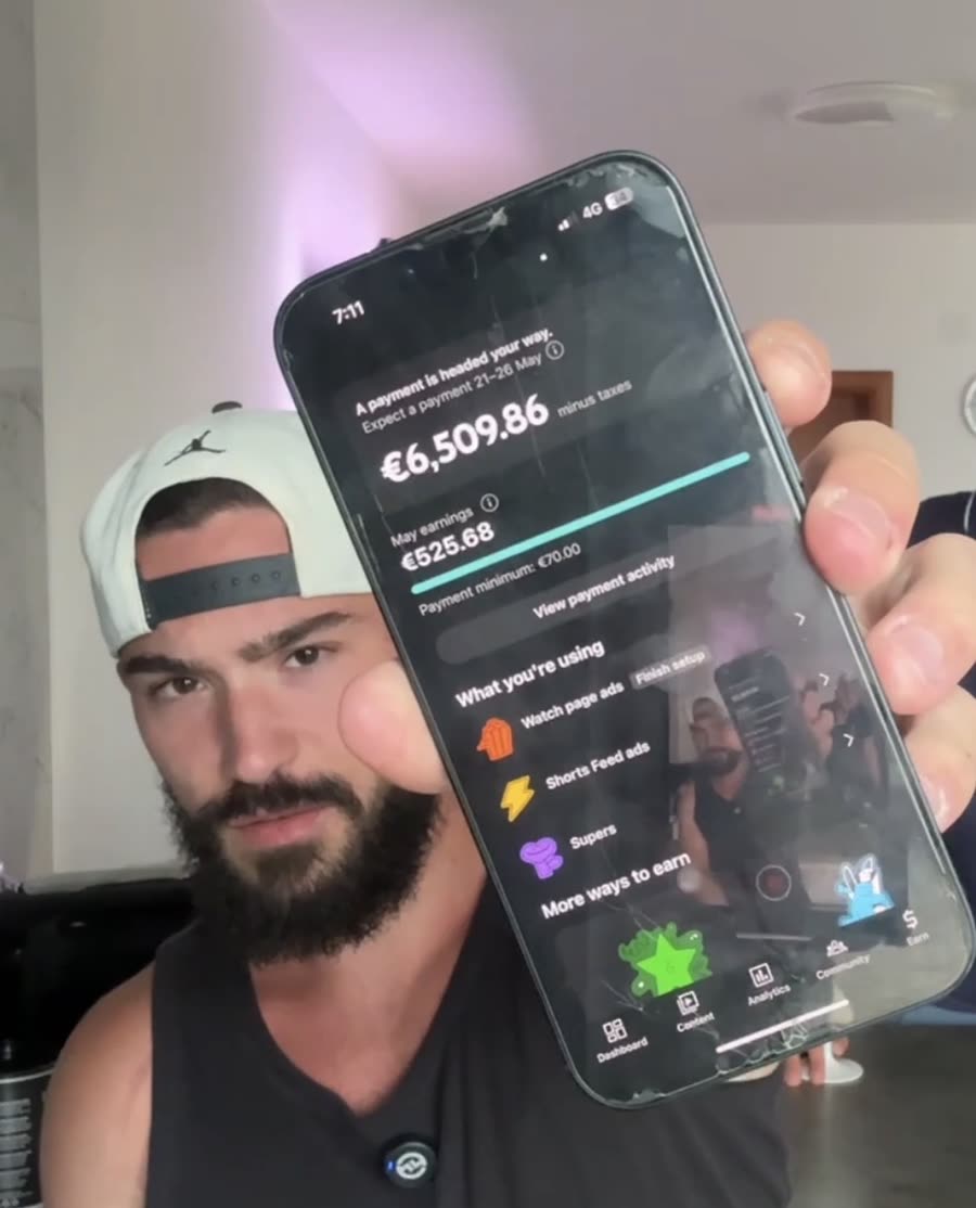 Član SideHustlea pokazuje zaradu na mobitelu